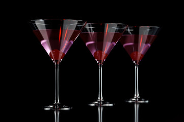 Three red cocktails in martini glass with cherry