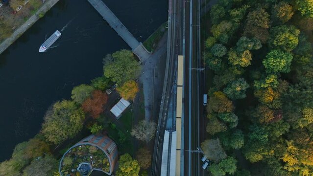 Birds eye view of S Bahn train crossing river on multitrack bridge. Autumn city at golden hour. Berlin, Germany