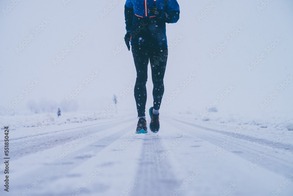 Wall mural Man running in winter on the snow