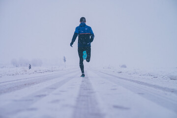 Fototapeta na wymiar Man running in winter on the snow