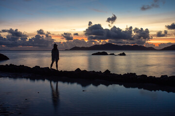 Une personne qui contemple le coucher de soleil à La Digue aux Seychelles