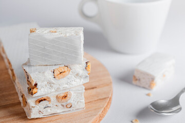 Delicious Italian festive torrone or nougat with nuts on light background