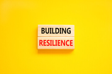 Building resilience symbol. Concept word Building resilience typed on wooden blocks. Beautiful yellow table yellow background. Business and building resilience concept. Copy space.