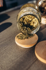 herbal tea. dried herbs. dried various herbs in next to a glass jar with rashes of herbs on a light background