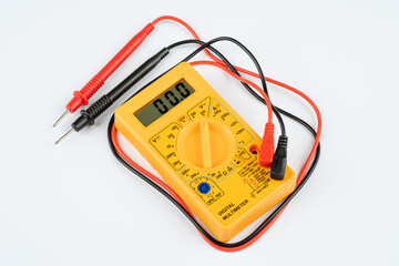 Digital multimeter with probes on a white background. 