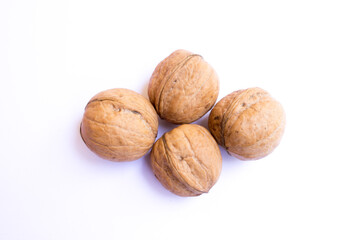 four large brown walnuts on a white background.