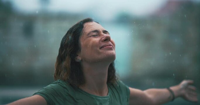 Young Serene Female Enjoy Summer Rain Holding Hands Up in Air. Adult Woman Resting Outside in the Rain Taking Deep Breath of Fresh Air, Healthy Calm Lady Relaxing Feel Stress Free Balance and Calmness