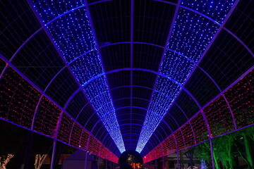 Palisades walkway decorated with colorful LED lights in blue and red at Christmas time in the...