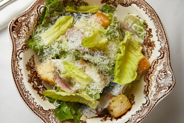 fresh caesar salad with anchovies on a beautiful plate - obrazy, fototapety, plakaty