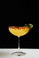 cocktail with vodka, green chili pod in martini glass on black background