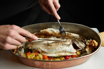 carving baked sea bass during dinner