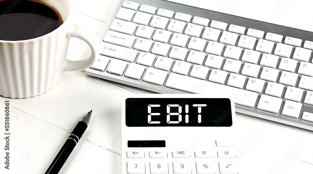 Poster ebit text on a calculator with keyboard and coffee