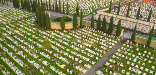 Aerial view on public cemetery at sunset. Catholic graves remember the dead.