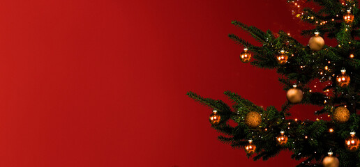 Weihnachtsbaum mit Goldenen Kugeln vor rotem Hintergrund