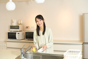 キッチンで洗い物をする若いアジア人女性