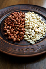 Raw peanuts in a clay bowl. Cajour and shelled beans