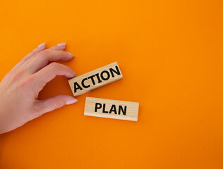 Action plan symbol. Wooden blocks with words Action plan. Beautiful orange background. Businessman hand. Business and Action plan concept. Copy space.