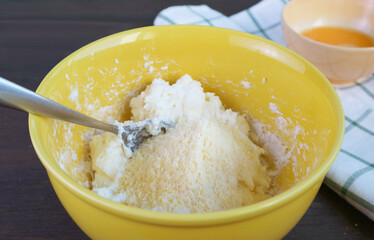 Parmesan cheese being added onto the dough for baking Brazilian cheese bread