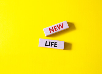 New life symbol. Wooden blocks with words New life. Beautiful yellow background. Business and New life concept. Copy space.