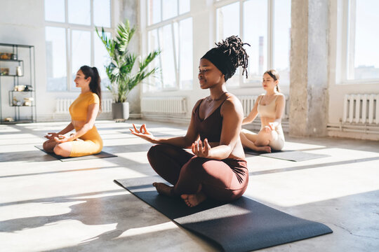 Meditating women practicing yoga in studio