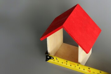 Selective focus image of miniature house and measuring tape with copy space. House renovation...