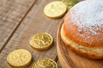 Happy Hanukkah. Hanukkah sweet doughnuts, gift boxes, white candles and chocolate coins on old  wooden background. Image and concept of jewish holiday Hanukkah. Top view.