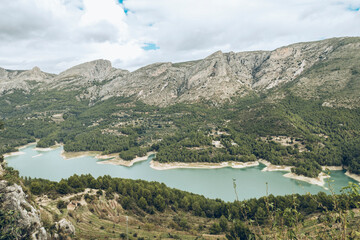 Aerial view of the Guadalest reservoir between mountains on a cloudy day