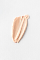 Creamy base fair tone product texture .Cosmetic fundation smear on white background. Make up swatch