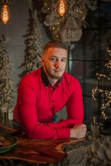 European young man in red shirt in winter atmosphere, fashionable concept