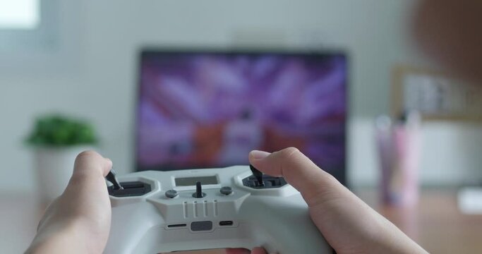 male hands control a drone flight in simulator on computer. close-up. fpv drone control
