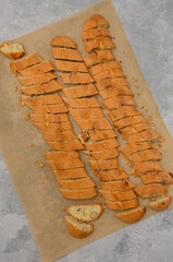 Traditional Italian cantuccini cookies with almonds on baking paper on a gray concrete background....