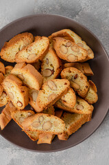 Traditional Italian cantuccini cookies with almonds on a plate on a gray concrete background. Top view.