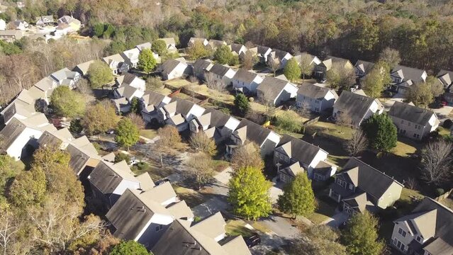 Aerial video upscale residential neighborhood two story houses and front garage in woodland area and lush green tree landscape outside Atlanta, Georgia, USA. High density suburban home large backyard