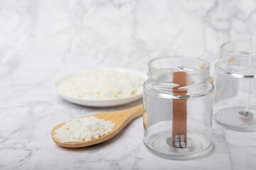 Basic set for homemade natural white eco-friendly soy wax candles in glass, wick, perfume on white marble. Hobby, business. Making candles with your own hands.Vegan product. Copy space.