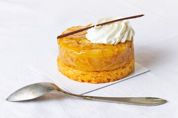Small single-portion apple tatin garnished with cream. 