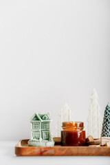 Merry Christmas decoration concept with burning candles and festive decor, christmas trees on light white background. Cozy home. Space for text.