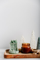 Merry Christmas decoration concept with burning candles and festive decor, christmas trees on light white background. Cozy home. Space for text.
