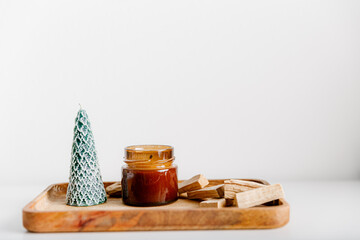 Merry Christmas decoration concept with burning candles and festive decor, christmas trees on light white background. Cozy home. Space for text.