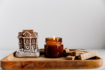 Merry Christmas decoration concept with burning candles and festive decor, christmas trees on light white background. Cozy home. Space for text.