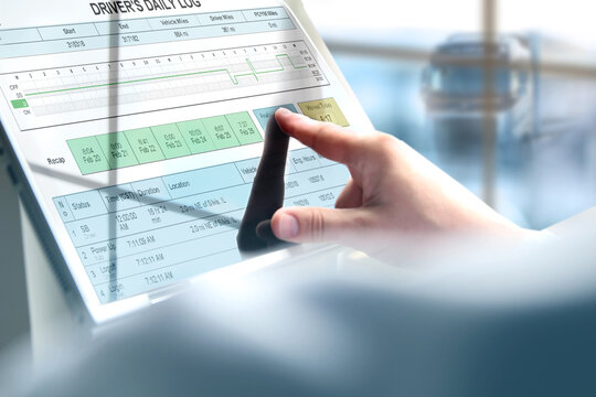 Safety manager is showing to Truck driver  th  electronic logbooks on a tablet