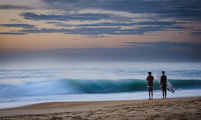 Fototapeta na wymiar Surfers at sunset waves, Hossegor