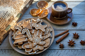 Traditional homemade gingerbread cookies and a cup of coffee on a sunny winter morning. Home comfort. Christmas mood, holiday atmosphere.