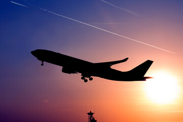 airplane taking off in evening backlight