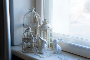 White figurines of hares and other decorations for the New Year on the window.
