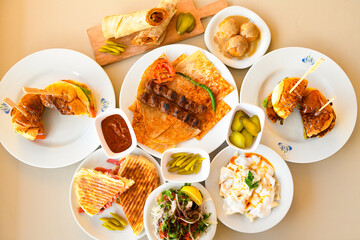 Traditional Turkish cuisine. Pizza, pita, pidesi, sucuk, hummus, kebab. Many dishes on the table. Serving dishes in restaurant. Background image. Top view, flat lay