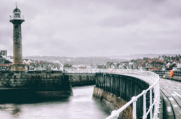 Fototapeta premium The Harbour Lighthouse & Curved Pier At Whitby On A Cold Winters Morning
