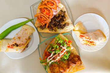 Traditional Turkish cuisine. Pizza, pita, pidesi, sucuk, hummus, kebab. Many dishes on the table. Serving dishes in restaurant. Background image. Top view, flat lay