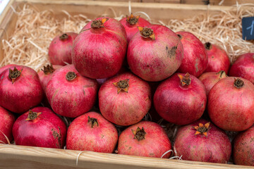 Fototapeta na wymiar Pomegranate fruits. A vegetable counter at a street market. Trade in seasonal goods.