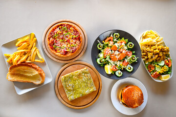Traditional Turkish cuisine. Pizza, pita, pidesi, sucuk, hummus, kebab. Many dishes on the table. Serving dishes in restaurant. Background image. Top view, flat lay