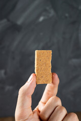Fingers holding a Brazilian Peanut Sweet called Paçoca
